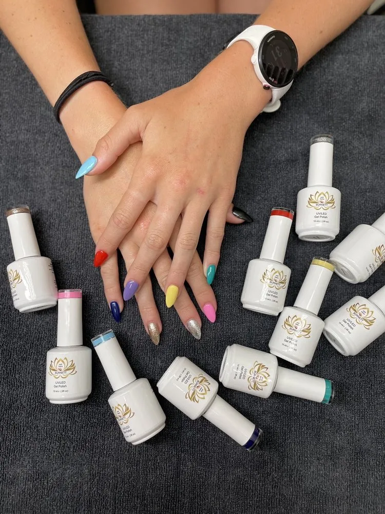 Rainbow multicoloured gel manicure, one colour per nail, with gel polish bottles at Sokha&rsquo;s Nails & Spa, Glen Allen